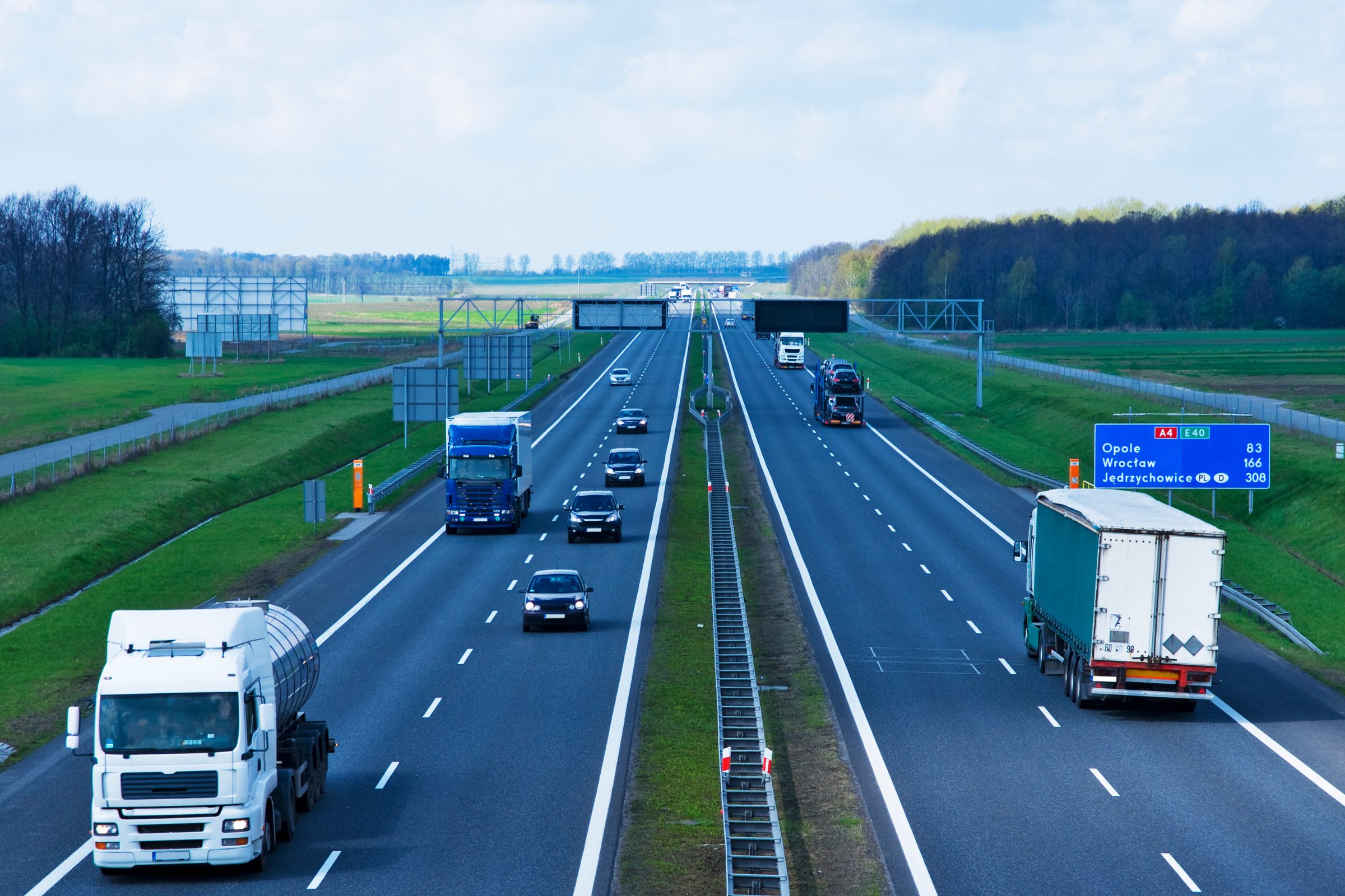 Samochody ciężarowe i osobowe na autostradzie A4 w Polsce z drogowskazem na Opole i Wrocław, opłaty drogowe e-TOLL