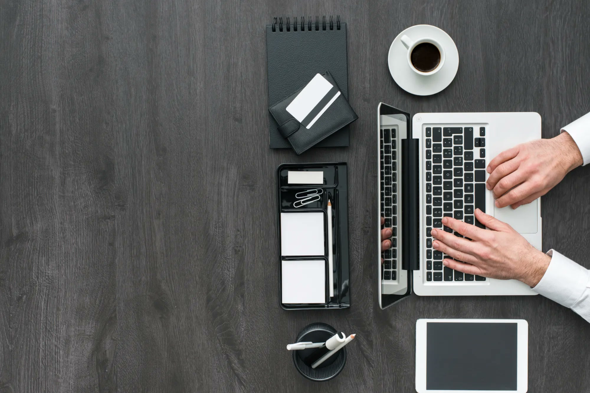 Praca na laptopie przy biurku, integracja systemów firmy z PractiQS przez interfejs API