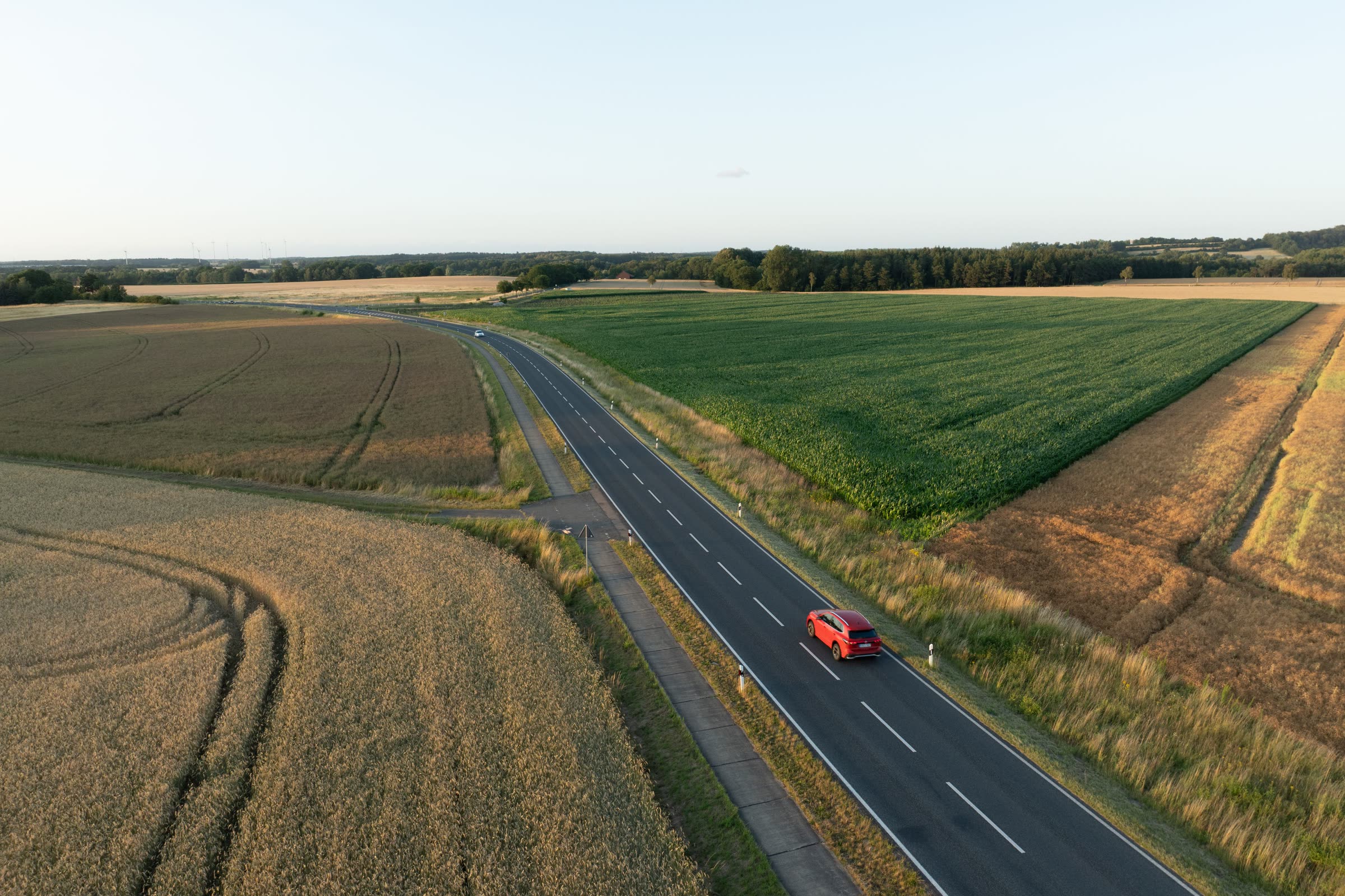 Samochód firmowy na drodze wśród pól z lotu ptaka, przejazd zapisany jako jazda służbowa albo prywatna