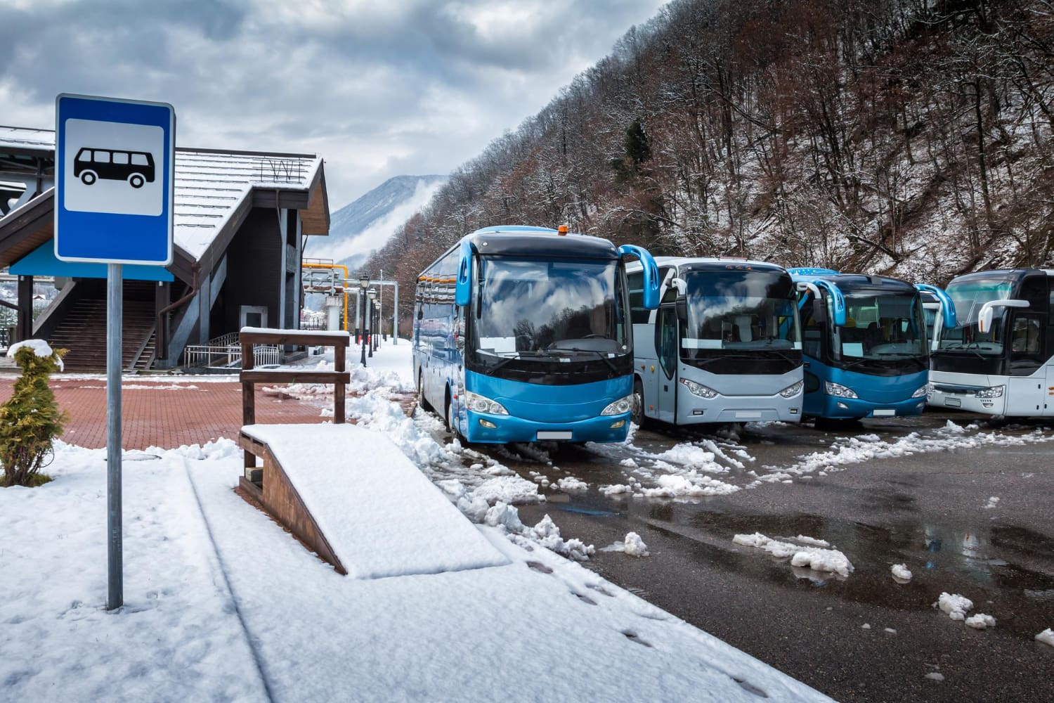 Autobusy na dworcu autobusowym zimą, w tle las i góry, monitoring GPS autobusów