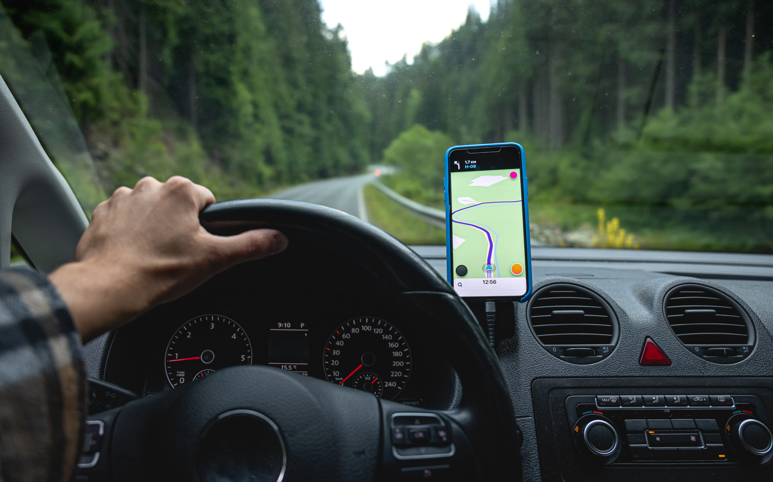 Telefon z aplikacją w uchwycie w samochodzie na leśnej drodze, identyfikacja kierowcy